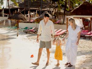 Luke Strom with wife and daughter walking on the beach.