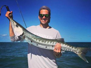 Luke Strom holding large fish on the ocean.